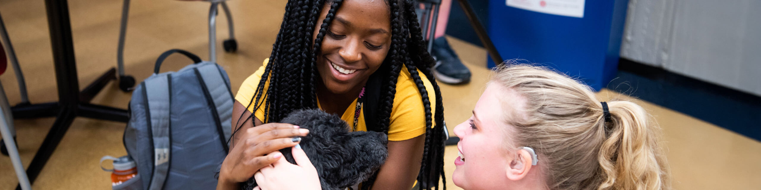 Students pet a dog.