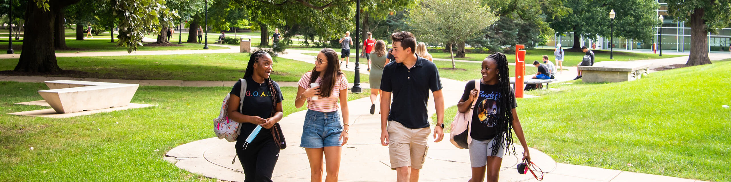 Four students walk on campus.